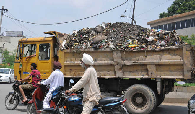 Uncovered garbage-laden vehicles trouble commuters