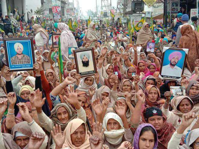 Carrying photos, families of deceased farmers protest