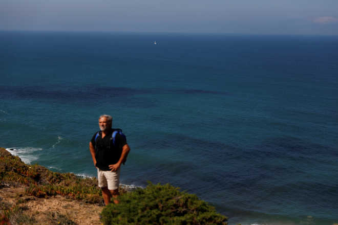 In Portugal, a man braves dangerous cliffs to clean-up the coast