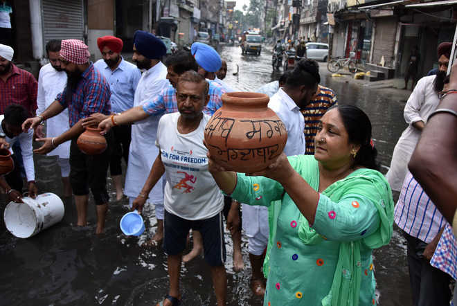 Protesters wave dirty water buckets